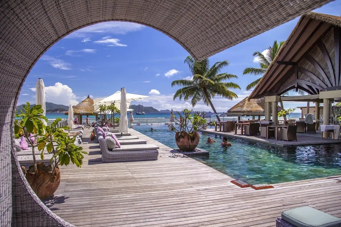 Zwembadpaviljoen met palmen aan zee op de Seychellen