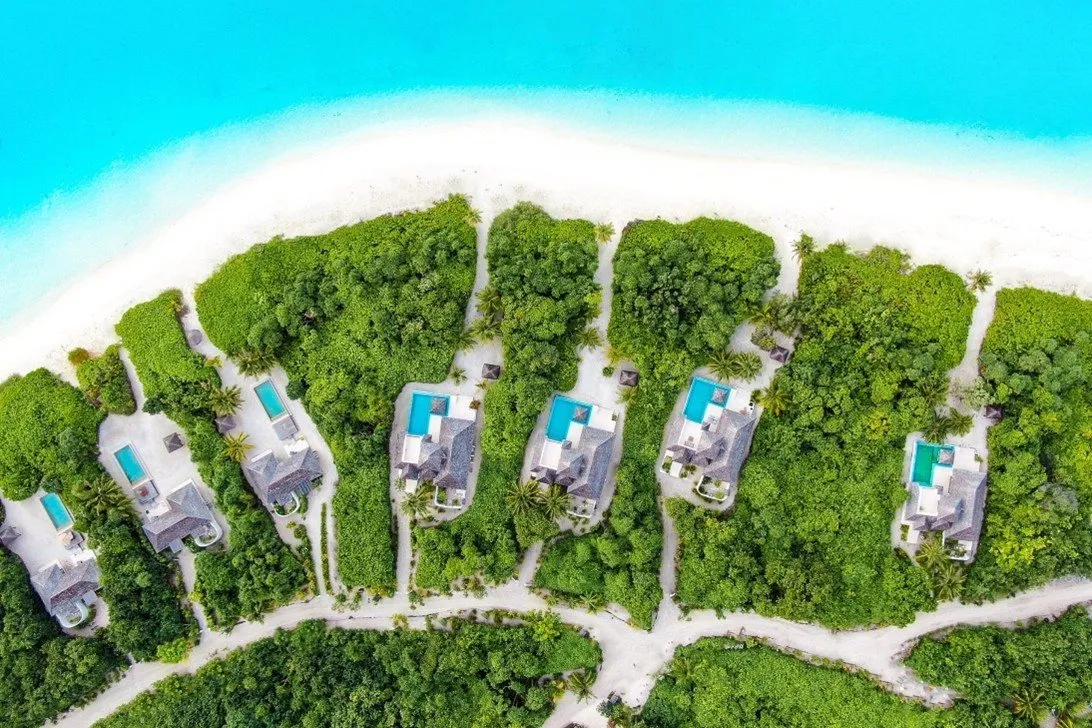 Luchtfoto van watervilla's aan een wit strand op de Malediven